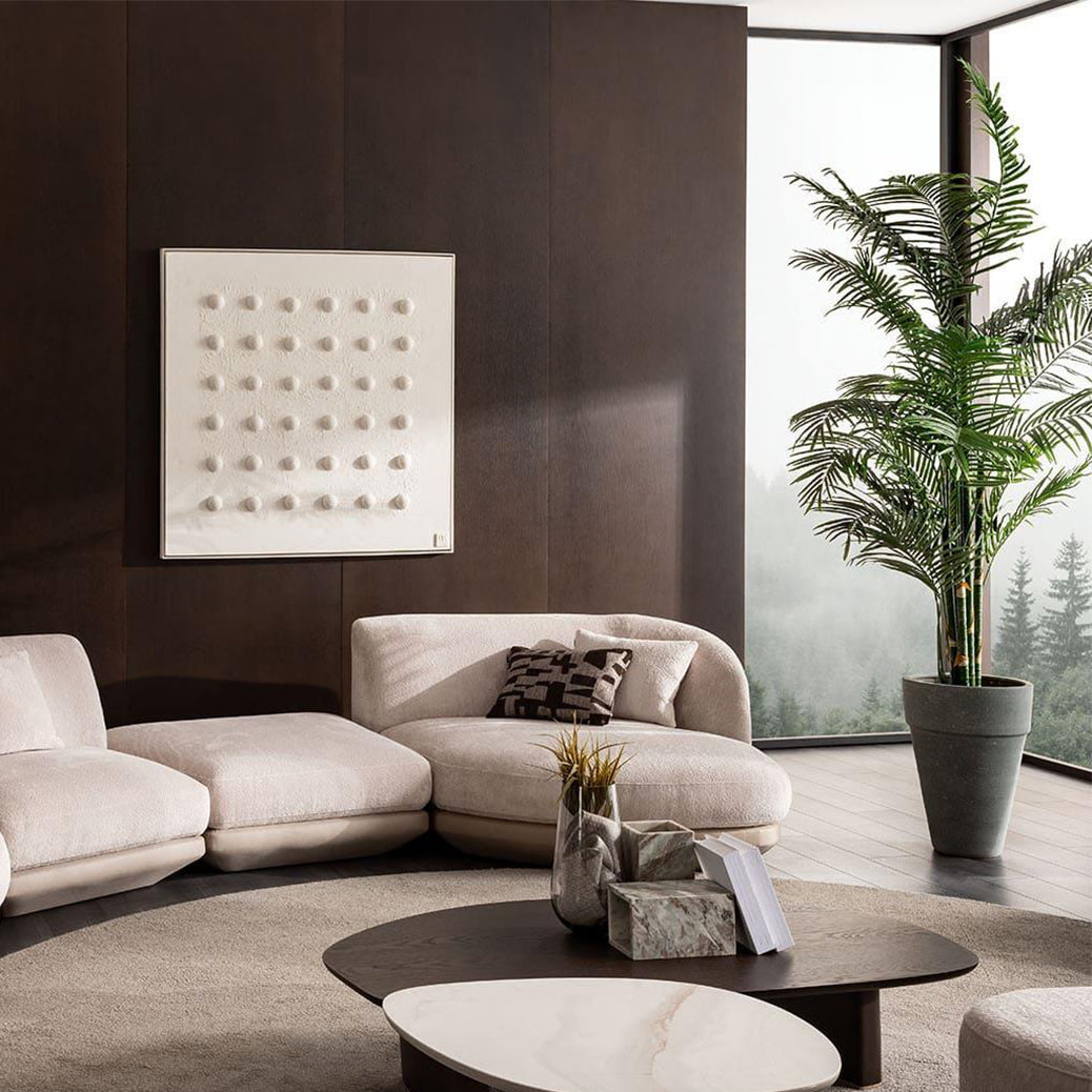 Modern living room with a beige sectional sofa, coffee table, and decorative elements.