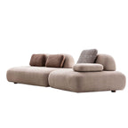Beige sofa with brown and patterned cushions on a white background